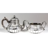 A Victorian silver circular tea pot of bulbous reeded form, the domed cover with turned finial, with