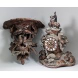 A 19th Century "Black Forest" carved wood cased mantel clock, the 4.25ins diameter carved wood