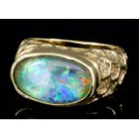 An 18ct gold mounted opal ring set with oval doublet opal (approximately 3ct), and with textured