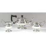 A George V silver three-piece tea service with squat circular bodies, reeded central girdle and