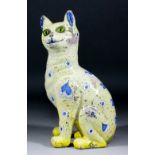 A late 19th Century Galle faience cat painted with blue hearts and circles on a yellow ground and