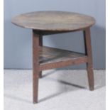 An 18th Century oak circular cricket table with four-plank top, on three triangular splayed legs and