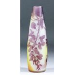 An early 20th Century Galle mauve overlay cameo glass vase of tall slender form, cut with a head