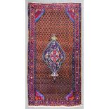 A Hamadan long rug woven in colours with a central lozenge shaped medallion filled with floral and