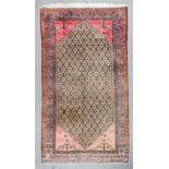 A Kolyai rug woven in muted colours with a central hexagonal lozenge filled with trellis design, the