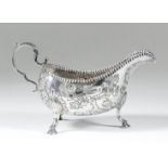 A George III "Irish" silver oval sauce boat with crimped rim, chased and embossed with birds perched