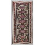 A Kazak Sewan runner woven with a central angular medallion filled with seven octagonal motifs,