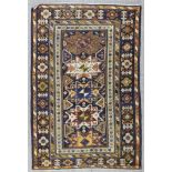 A Caucasian Leshghi rug woven in colours with four and half star pattern medallions within wide