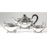 An Edward VII silver oval three-piece tea service of lobed form on four scroll feet, comprising -