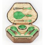 A George V lady's silver and green enamel backed nine-piece dressing table set with emerald green