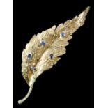 A modern 18ct gold mounted and sapphire brooch of leaf pattern, set with five small sapphires,