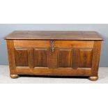 An 18th Century French provincial oak coffer with two plank cleated top, the front with four