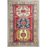 A Shirvan rug woven in colours with three bold octagonal medallions filled with hooked and geometric