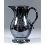 An 18th Century English Jackfield pottery jug with traces of an overglaze design in silver and