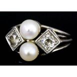 A modern white coloured metal mounted pearl and diamond ring, set with two central cultured pearls