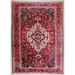 A Bahtiari carpet woven in colours with bold central medallion and spandrels, the medallion and