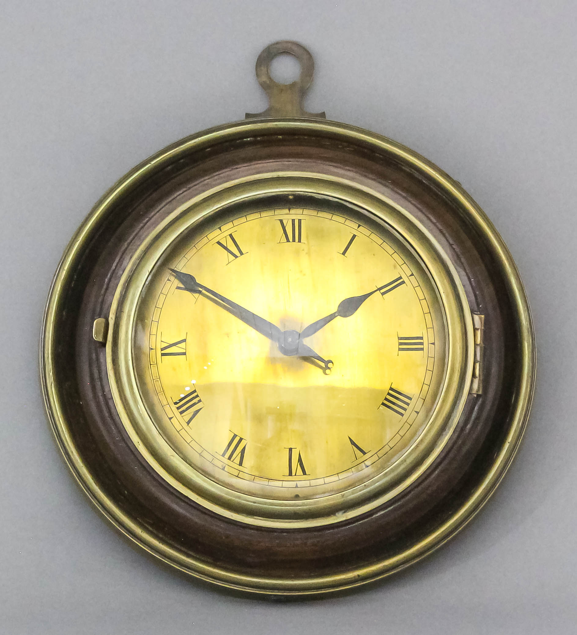 A mahogany and brass mounted circular "Sedan" clock, the 3.875ins diameter brass dial with Roman