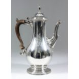 A George III silver bulbous coffee pot, the domed lid with urn finial and bead mounts to rim, cast