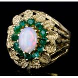 A modern 9ct gold mounted opal and emerald ring, set with central oval opal, 5mm x 7mm, surrounded