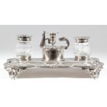 A William IV silver rectangular inkstand of shaped and moulded outline with leaf and floral mount to