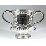 A George I silver two-handled cup, the bell shaped body embossed with oval cartouche with leaf