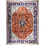 A Sarouk carpet woven in colours with a central lozenge shaped medallion and conforming spandrels,