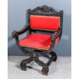 A Victorian carved dark oak armchair, the shaped crest rail carved with lion's mask and scroll