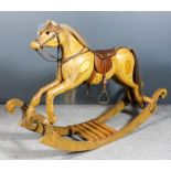 A modern laminated wood rocking horse with horsehair mane and tail and leather saddle, on shaped