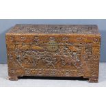 A Chinese hardwood rectangular blanket box, the whole carved with a battle scene, on block feet,