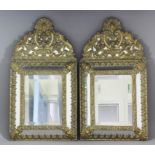 A pair of 19th Century Continental brass cushion wall mirrors, the repousse decoration of acanthus