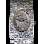 A lady's 9ct white gold cased manual wind cocktail wristwatch, the oval dial with Arabic numerals,