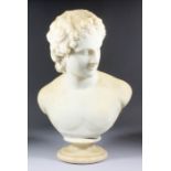 A 19th Century white marble bust of a young man, possibly Apollo, on circular socle, 20ins high