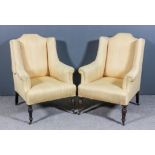 A pair of early 20th Century wingback easy chairs with shaped backs, outscroll arms, upholstered