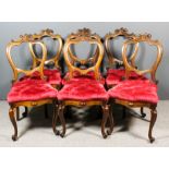 A set of six Victorian rosewood balloon back dining chairs, the shaped backs with carved scroll