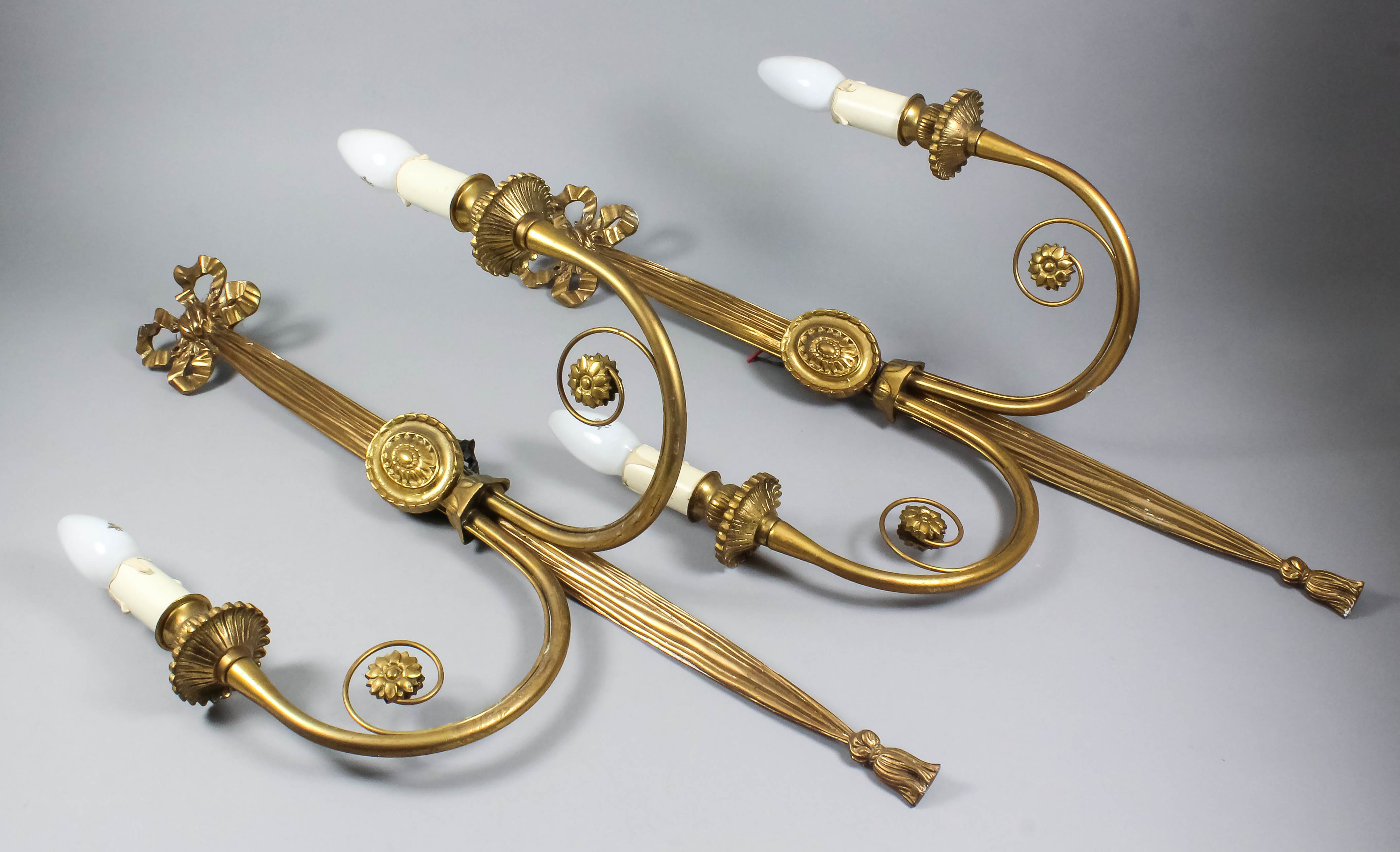 A pair of gilt brass two-branch wall lights of "Neo Classical" design, the moulded ribbon pattern