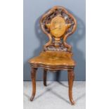 A 19th Century Swiss carved walnut musical hall chair, the shaped back of rustic form carved with