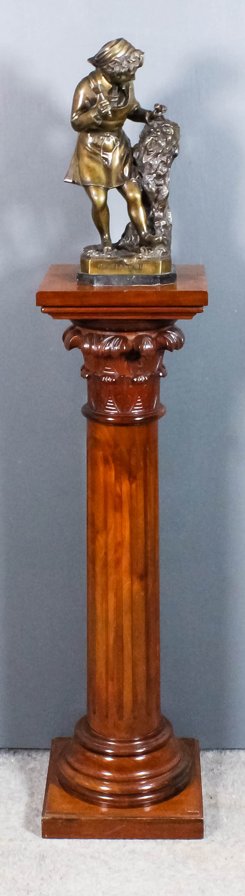A mahogany square topped pedestal with turned and fluted column with Corinthian capital and square