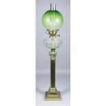 A late Victorian oil lamp with etched green tinted glass spherical shade, slice and fan cut