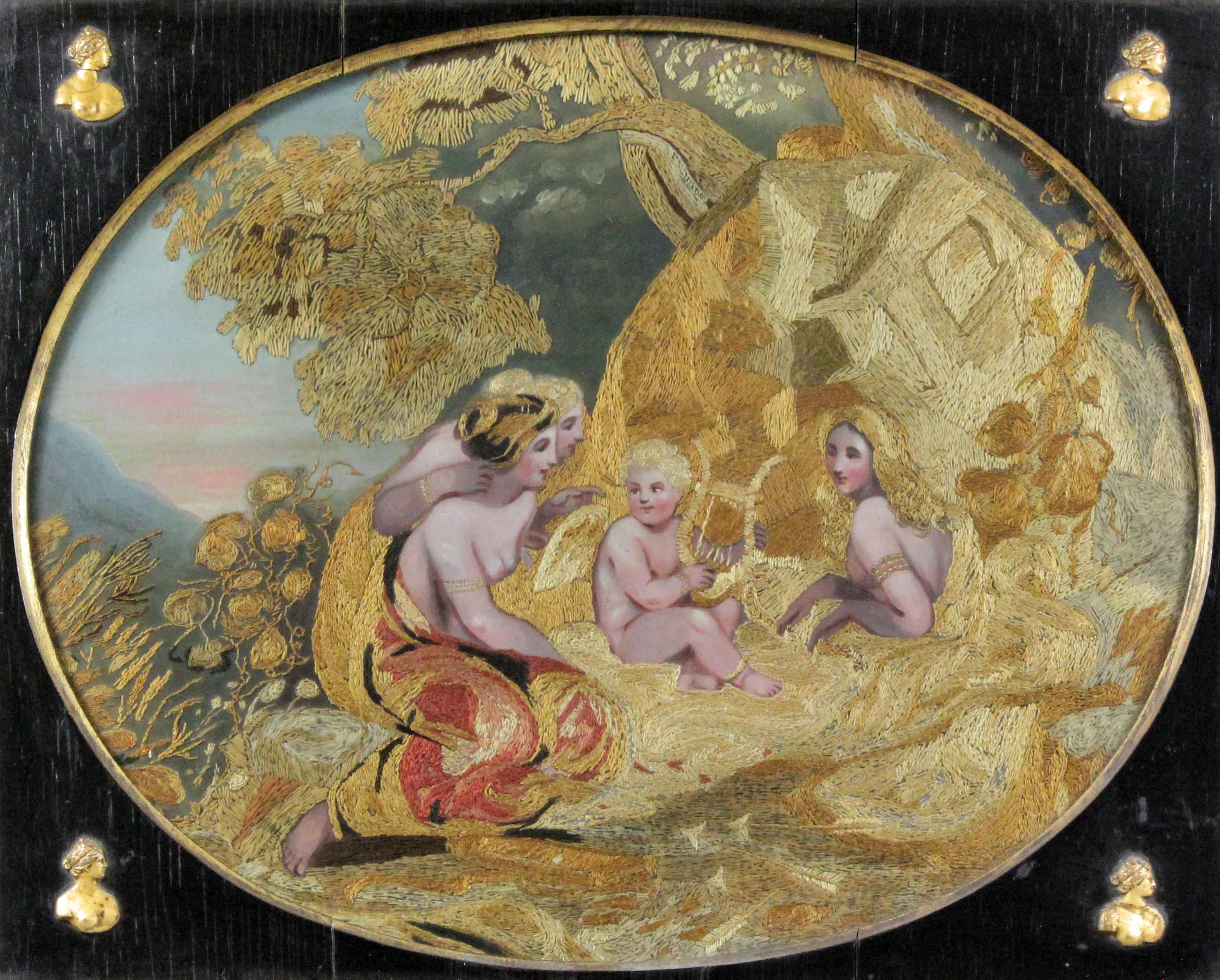 A George III coloured silk and gouache oval picture of three classical maidens being serenaded by