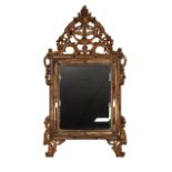 A NINETEENTH CENTURY/EARLY TWENTIETH CONTINENTAL CARVED GILTWOOD MIRROR, the bevelled plate and