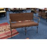 A LATE NINETEENTH CENTURY BLACK WROUGHT IRON WIRE PATTERN TWO SEATER SETTEE with woven cane back,