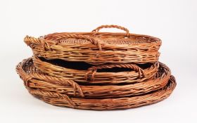 PAIR OF CIRCULAR TWO HANDLED WICKER BREAD TRAYS, 22" (56cm) diameter, and a MATCHING SET OF THREE,
