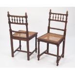 A SET OF FIVE EARLY 1900's OAK SINGLE DINING CHAIRS, with spindled backs and cane seats, on turned