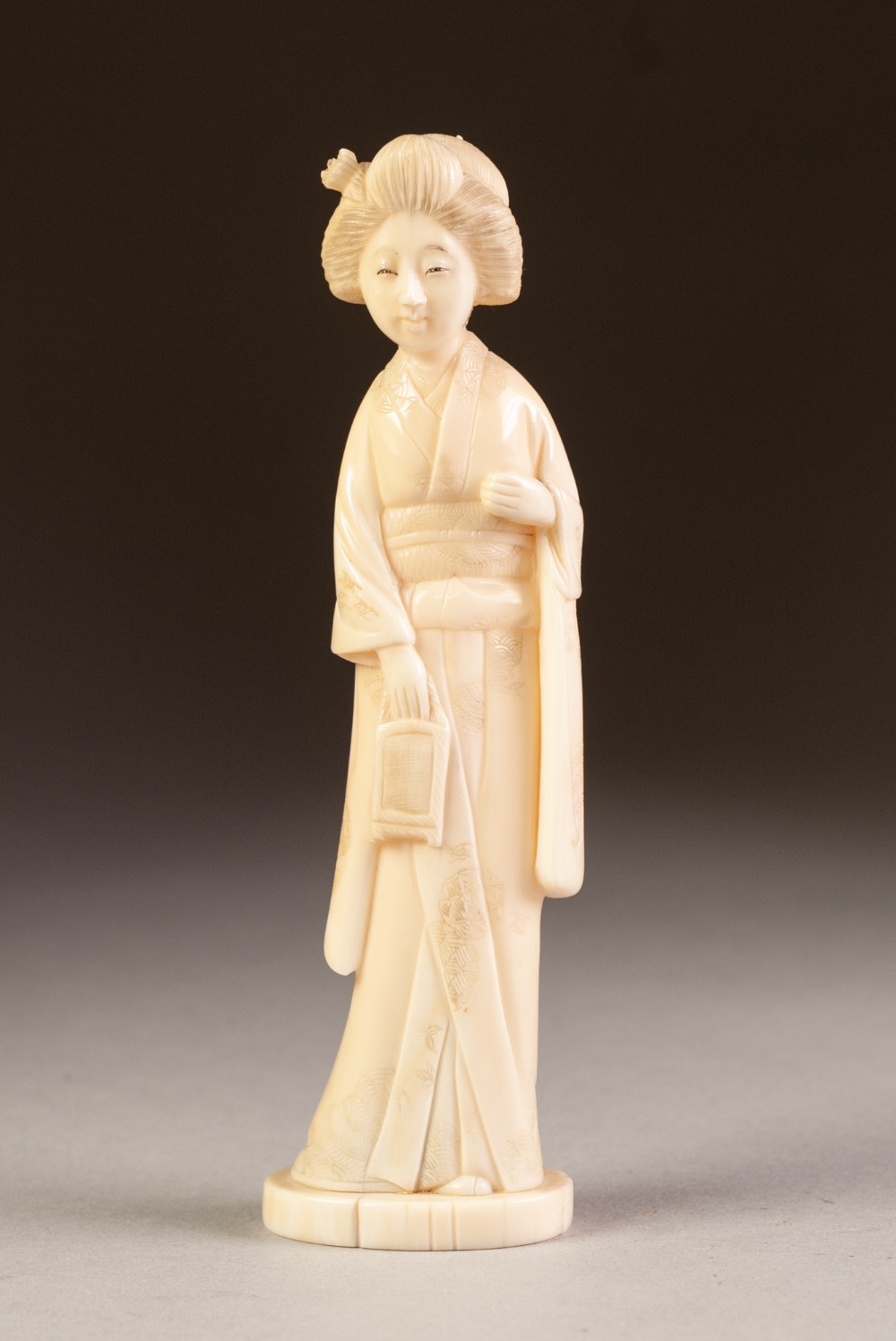 JAPANESE MEIJI PERIOD CARVED ONE PIECE IVORY FIGURE OF A GEISHA, 6" (15.2cm) high