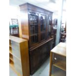 A REPRODUCTION BOOKCASE, GLAZED UPPER PORTION WITH DRAWERS AND CUPBOARDS UNDER