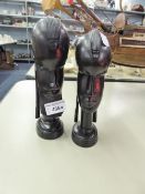 TWO CARVED EBONY AFRICAN HEAD BUSTS, one female (8 1/2" high) and other male (9" high), raised on