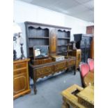 A MID TWENTIETH CENTURY OAK DRESSER, THE RAISED BACK WITH THREE SHELVES EITHER SIDE OF A CUPBOARD