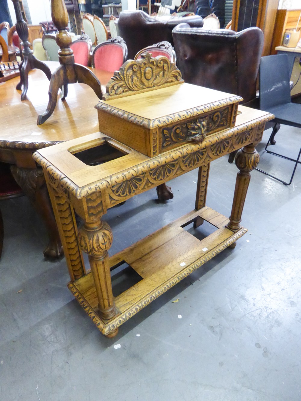 A 20TH CENTURY OAK HALL STAND WITH RAISED CENTRAL DRAWER HAVING LION HANDLE, UMBRELLA STANDS TO
