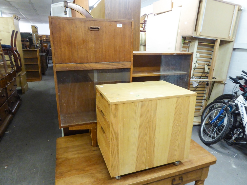 A TEAK STEP TOP BOOKCASE WITH GLASS SLIDING DOORS AND A PINE THREE DRAWER FILING CABINET (2)