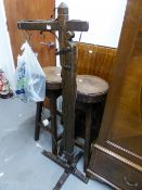 A JUST PRE-WAR OR POST-WAR WARING AND GILLOW CARVED OAK DRINKS BAR AND THREE BAR STOOLS